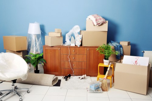 Mover carrying furniture through a residential entrance in Charlton